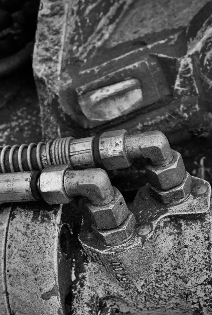 Detailed view of industrial metal components with hydraulic fittings, showcasing wear and texture.