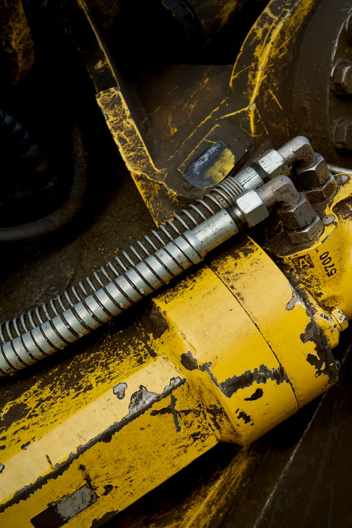 Industrial machinery close-up showing hydraulic cylinders and metal tubing details.